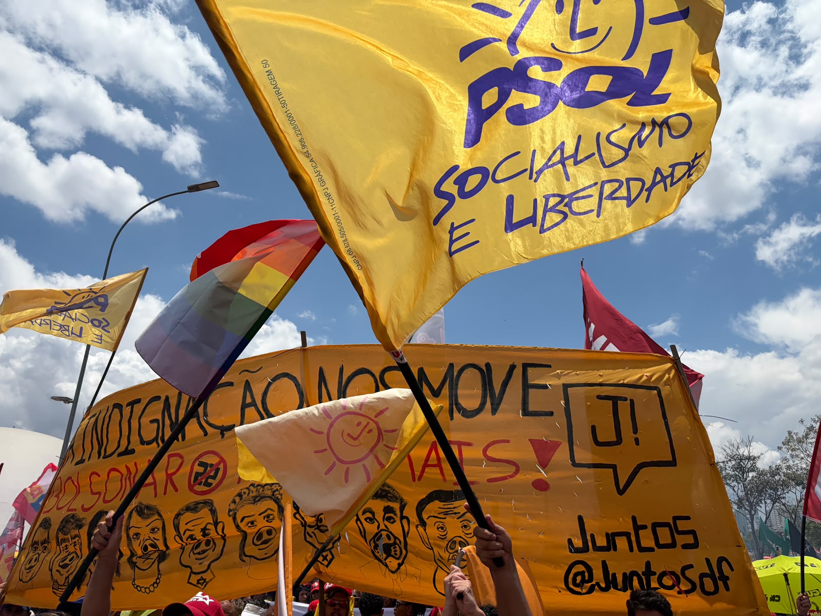 Mulher negra com punho levantado em meio à uma manifestação de rua